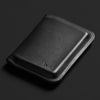 Black leather wallet with 'bellroy' branding on a dark background