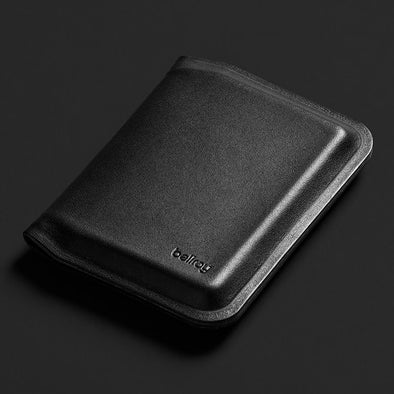 Black leather wallet with 'bellroy' branding on a dark background