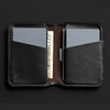 Black leather wallet with card slots on a black background