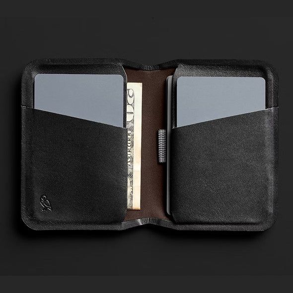 Black leather wallet with card slots on a black background
