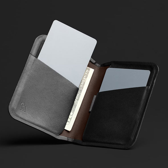 Three card holders in gray, brown, and black on a dark background