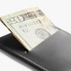 Gray wallet with a twenty-dollar bill sticking out of it on a white background
