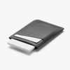 Black leather cardholder with a white card on a light gray background