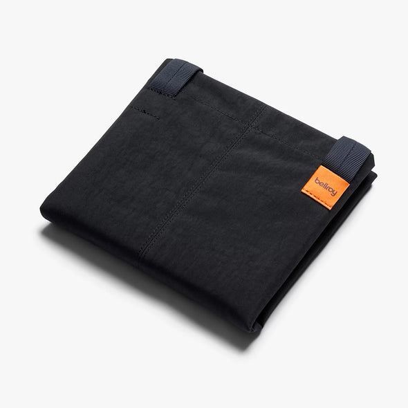 Black fabric roll with an orange label on a white background