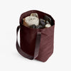 Bellroy City Tote Burgundy with various items on a white background