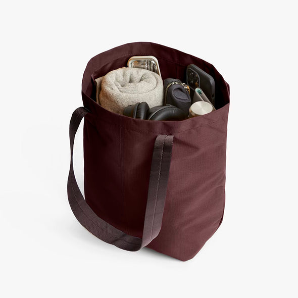 Bellroy City Tote Burgundy with various items on a white background