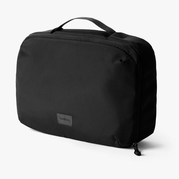 Black travel bag with a visible brand label on a white background