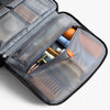 Open toiletry case with cosmetic items on a light gray background