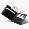 Black leather wallet with money and cards on a white background