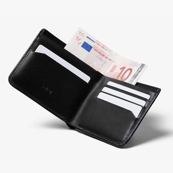 Black leather wallet with money and cards on a white background