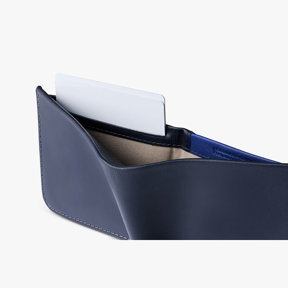 Navy blue leather wallet with a white card on a white background