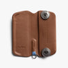 Brown leather key case with metallic lock mechanism on a white background