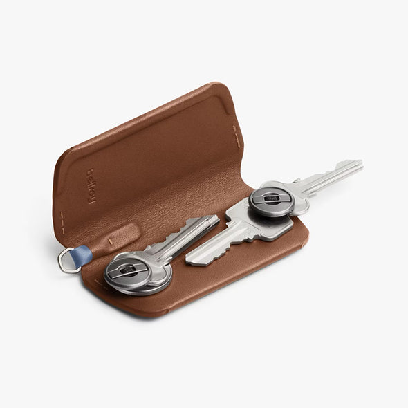 Brown leather key holder with keys on a white background