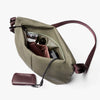 Green crossbody bag with a purple strap and a matching wallet on a white background