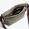 Open beige bag with items inside on a white background