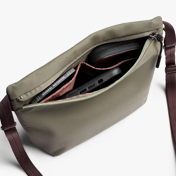 Open beige bag with items inside on a white background