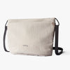 Beige shoulder bag with black straps on a white background, featuring the Bellroy logo.