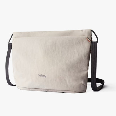 Beige shoulder bag with black straps on a white background, featuring the Bellroy logo.