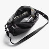 Black crossbody bag with a shoulder strap on a white background