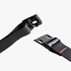 Two black webbing straps with plastic buckles on a white background