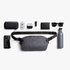 Collection of items including a gray waist bag, phone case, water bottle, and accessories on a white background.