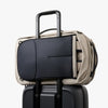 Black duffel bag on top of a suitcase with a beige backpack
