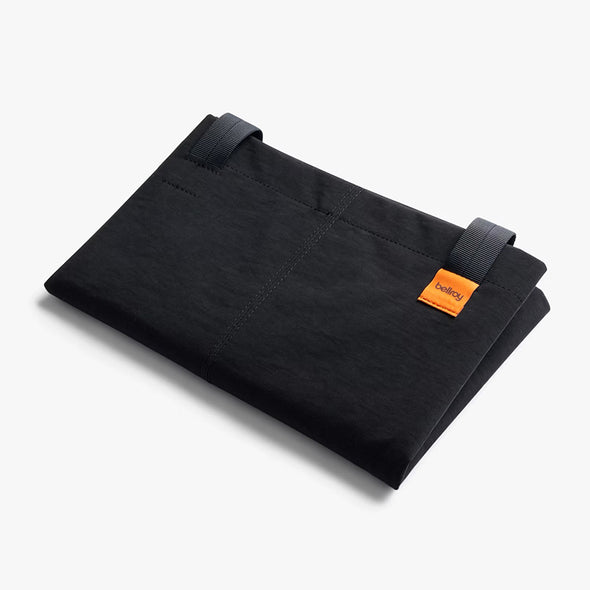 Black folded Bellroy Market Tote with an orange label on a white background