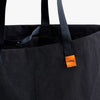 Black tote bag with orange tag featuring 'bellroy' brand on a white background