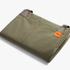 Folded green pants with an orange label on a white background