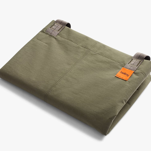 Folded green pants with an orange label on a white background