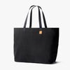 Black tote bag with a small orange label on a white background