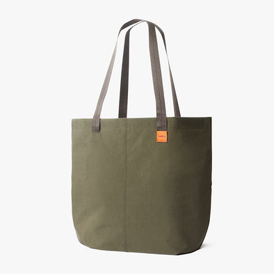 Green tote bag with brown handles on a white background