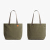 Two green tote bags with brown handles on a white background