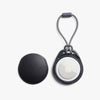 Black and gray keychain device with a white circular component on a white background