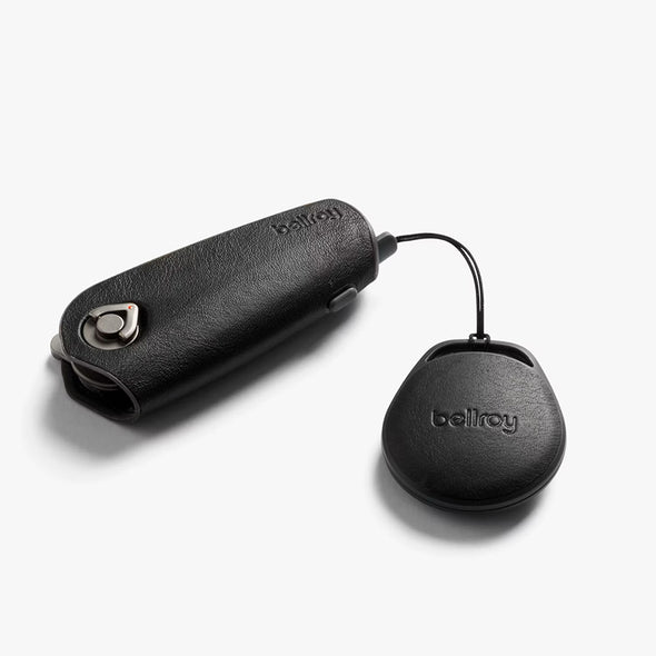 Black leather key case with keychain attachment on a white background, featuring the brand 'bellroy'.