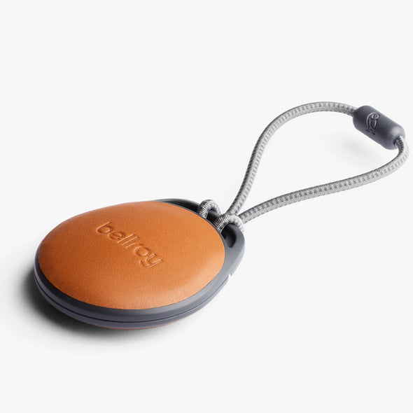 Round brown keychain with a gray cord and 'bellroy' branding on a white background