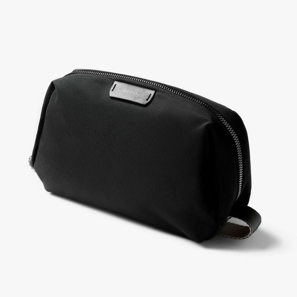 Black toiletry bag with a silver zipper on a white background
