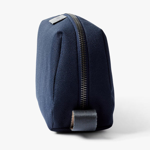 Navy blue toiletry bag with a gold zipper on a white background