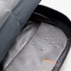 Gray backpack with water droplets demonstrating water resistance on a white background