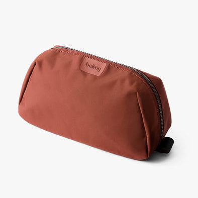 Brown toiletry bag with a visible brand logo on a white background