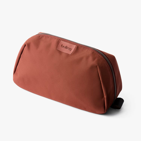 Brown toiletry bag with a visible brand logo on a white background