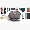Gray shoulder bag with various items arranged around it on a white background