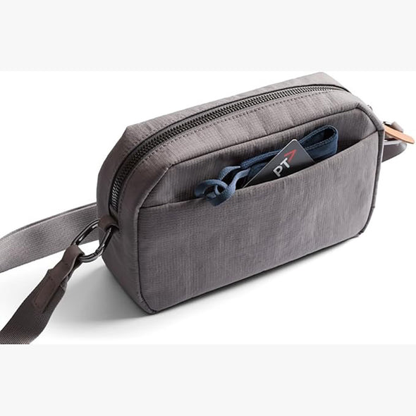 Gray crossbody bag with a strap on a white background