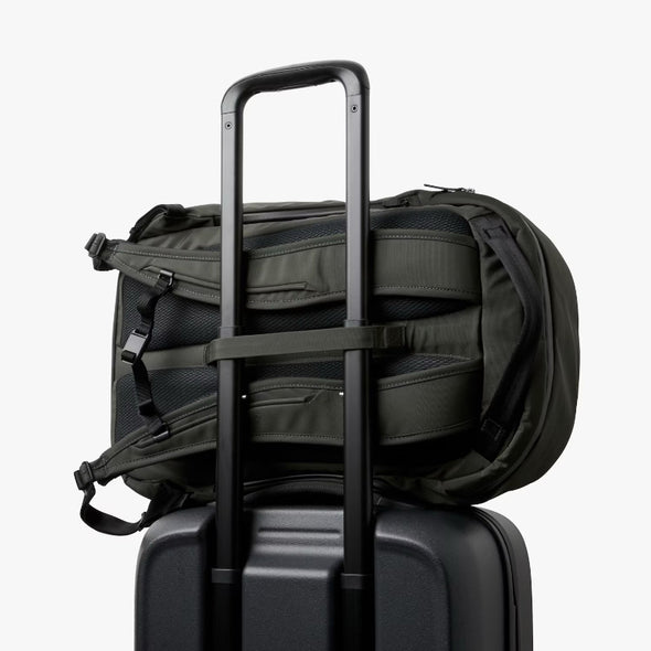 Bellroy Transit Workpack Pro 28L Olive backpack with a handle on top of a black suitcase
