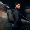 Man with a backpack standing against a blurred background