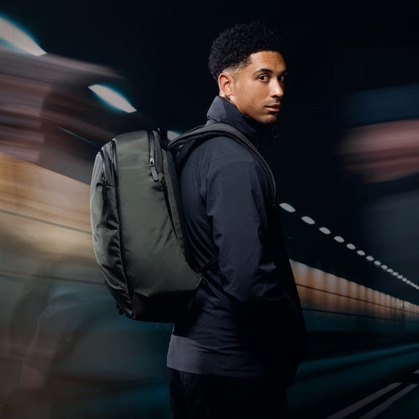 Man with a backpack standing against a blurred background