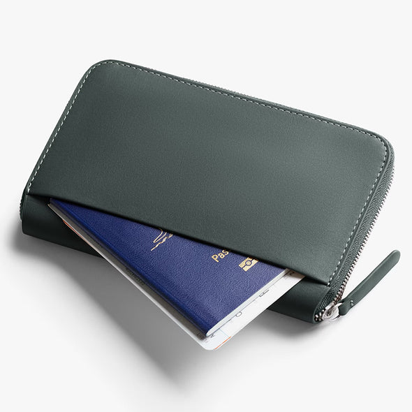 Green wallet with a passport inside on a white background