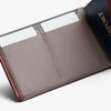 Brown leather wallet with card slots and a passport on a white background
