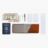 Wallet with passport, money, and other travel items on a white background