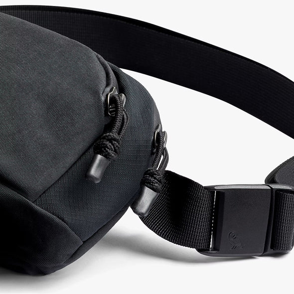 Black waist bag with a strap on a white background